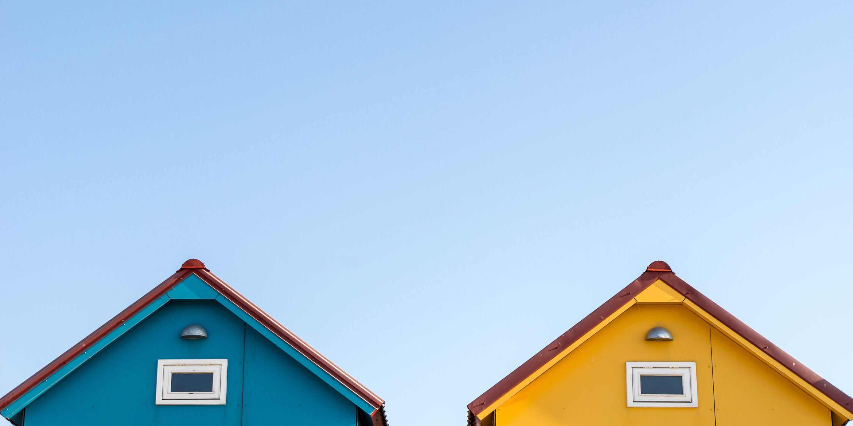 roofs of small blue and yellow houses with a light colored background